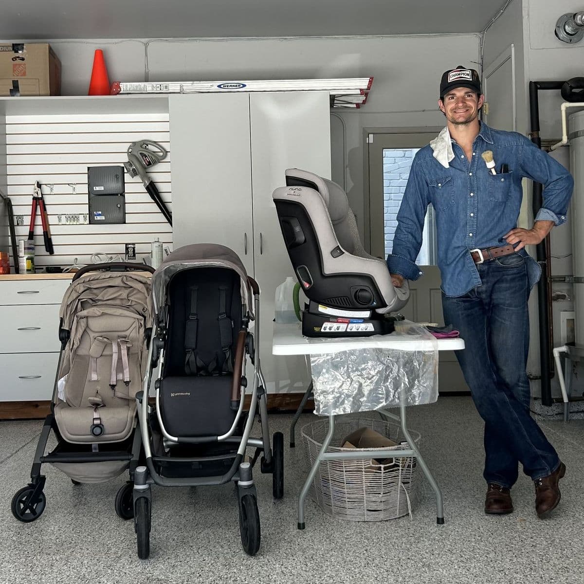 Trevor with freshly cleaned strollers and a car seat, ready to go