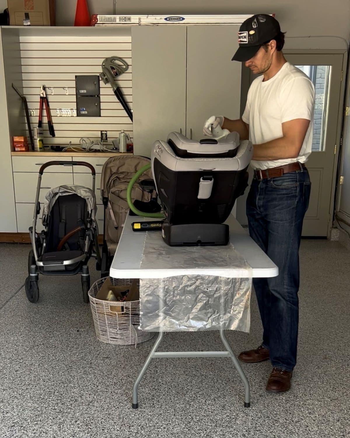 Trevor cleaning a car seat in his garage workshop